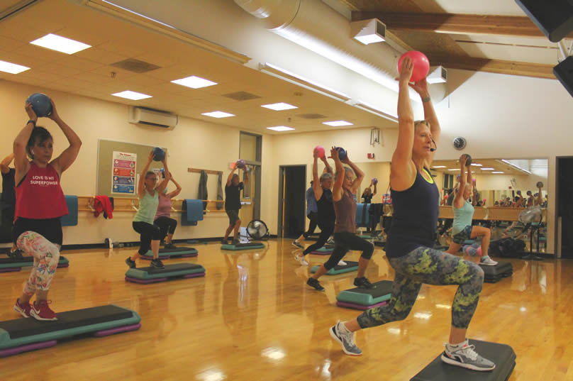 Exercise class with instructor and students using balls